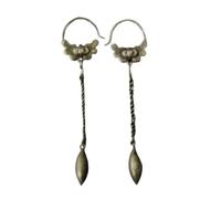 A pair of vintage, old-fashioned, tassel earrings with a retro, worn-out feel, belonging to a minority ethnic group.