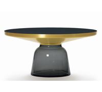 Modern: Bell Coffee Table Couchtisch Messing von ClassiCon Den Beginn der Zusammenarbeit von Designer Sebastian Herkner und ClassiCon markiert der Bell Table. Innerhalb weniger Jahre wurde dieser Entwurf zu einer Art Klassiker - vermutlich wegen der unerwarteten Materialwahl : Glas wird im Kopf mit filigran und zerbrechlich assoziiert. Im Falle des Bell Tables ist das Glas jedoch massiver Halt in Form des Tischfußes. Diese Version zeichnet sich zudem durch den Metallaufsatz aus massivem Messing aus, der sich farblich abhebt und einen tollen Kontrast bietet. Designer Sebastian Herkner Sebastian Herkner studierte Produktdesign an der Hochschule für Gestaltung in Offenbach . Schon während seines Studiums konzentrierte er sich auf die Gestaltung von Objekten und Möbeln, die sich durch die Kombination von traditioneller Handwerkskunst und moderner Technologie auszeichnen. Subtile Details sowie die natürliche Schönheit der verwendeten Materialien stehen zusätzlich im Fokus. Herkner gründete 2006 sein eigenes Designstudio in Offenbach am Main und hat seither Produkte für zahlreiche namhafte Unternehmen entworfen. Seine Arbeiten wurden bereits vielfach ausgezeichnet. Material und Format Der Tisch besteht aus einem mundgeblasenen Glasfuß in verschiedenen Farben und einem Metallaufsatz aus massivem Messing . Die Tischplatte besteht aus schwarz lackiertem Kristallglas . Der Tisch hat einen Durchmesser von 75 cm und ist 36 cm hoch.
