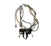 handmade beaded heavy necklace with black bow and pearl elements.