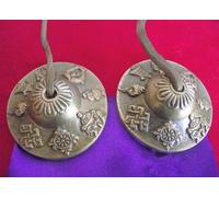 Tibetan Buddhist Astamangala Hand Bells on Leather Cord; embossed with the 8 Buddhist Symbols of Happiness - 60mm Diameter; comes in a Satin Drawstring Pouch. Use as a Meditation Aid; for Space Clearing; Healing - Sold by Spiritual Gifts. Usually dispatched within 2 working days.