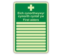 V Safety First Aiders Sign - 300 x 450 mm - Welsh/English | Glow In The Dark | Double Glow Rigid Plastic | First Aid Signage - Made in Britain