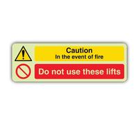 V Safety Glow In The Dark Caution In The Event Of Fire Do Not Use These Lifts Sign - Landscape Format - 750 x 250 mm - Made From Double Glow Self Adhesive Vinyl - Fire Safety Signage - Made in Britain